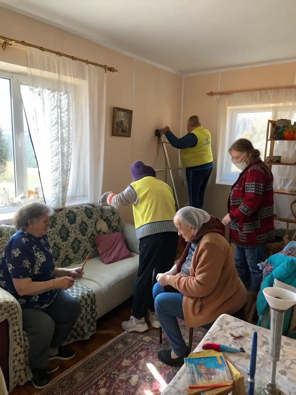 A photo of volunteers assisting elderly residents with home maintenance and providing companionship in a rural village.